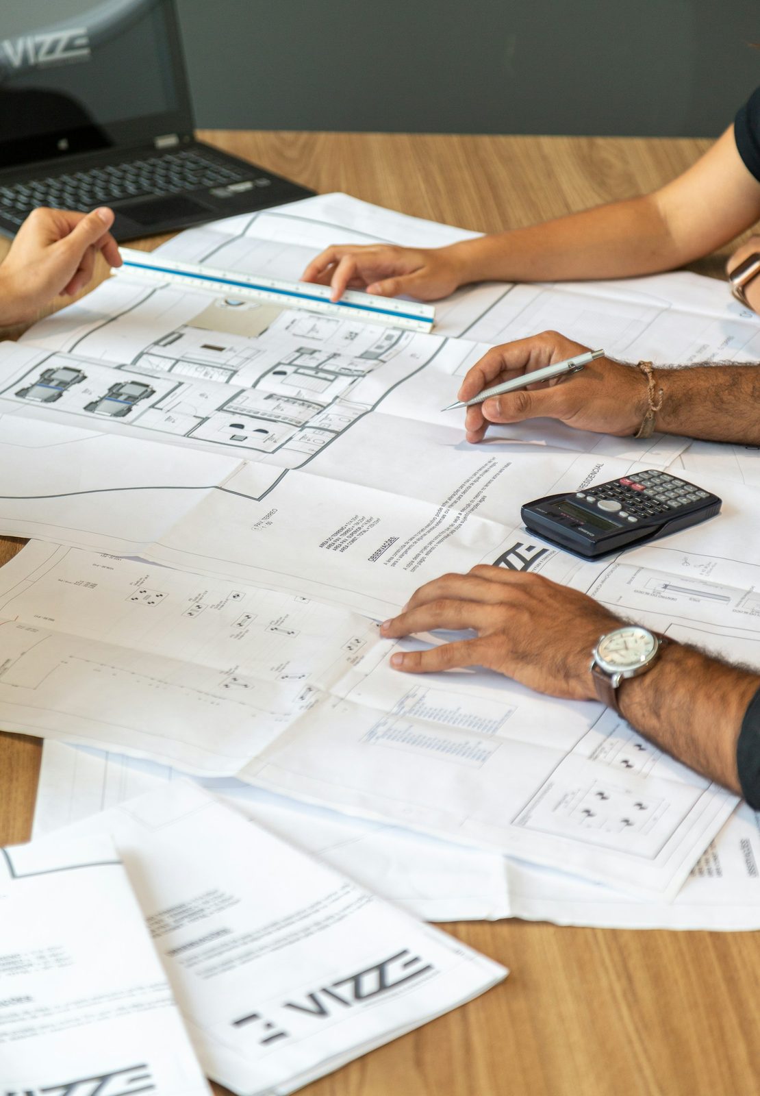 Builder and client reviewing renovation plans together at a table