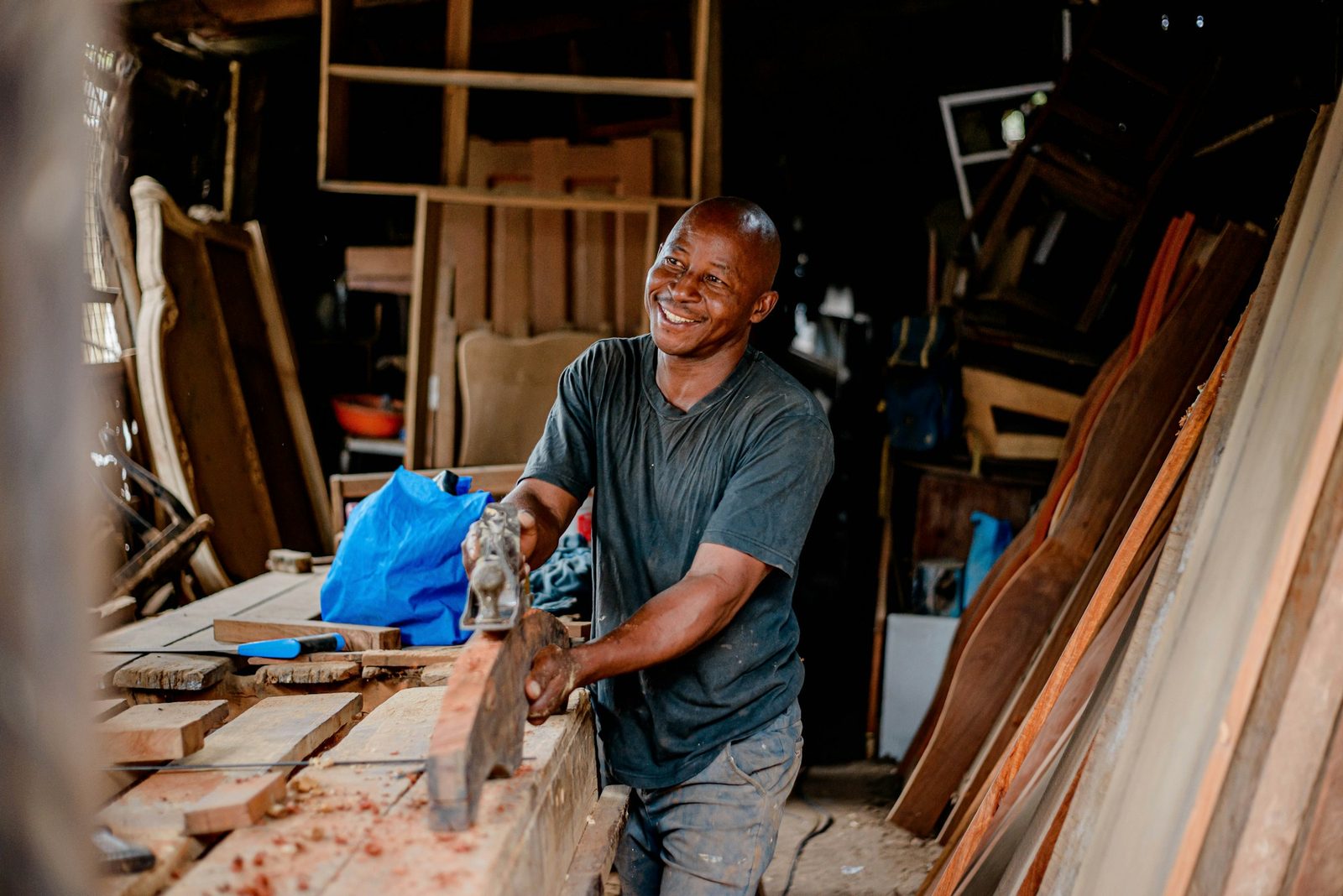 Smiling carpenter at work in a timber workshop