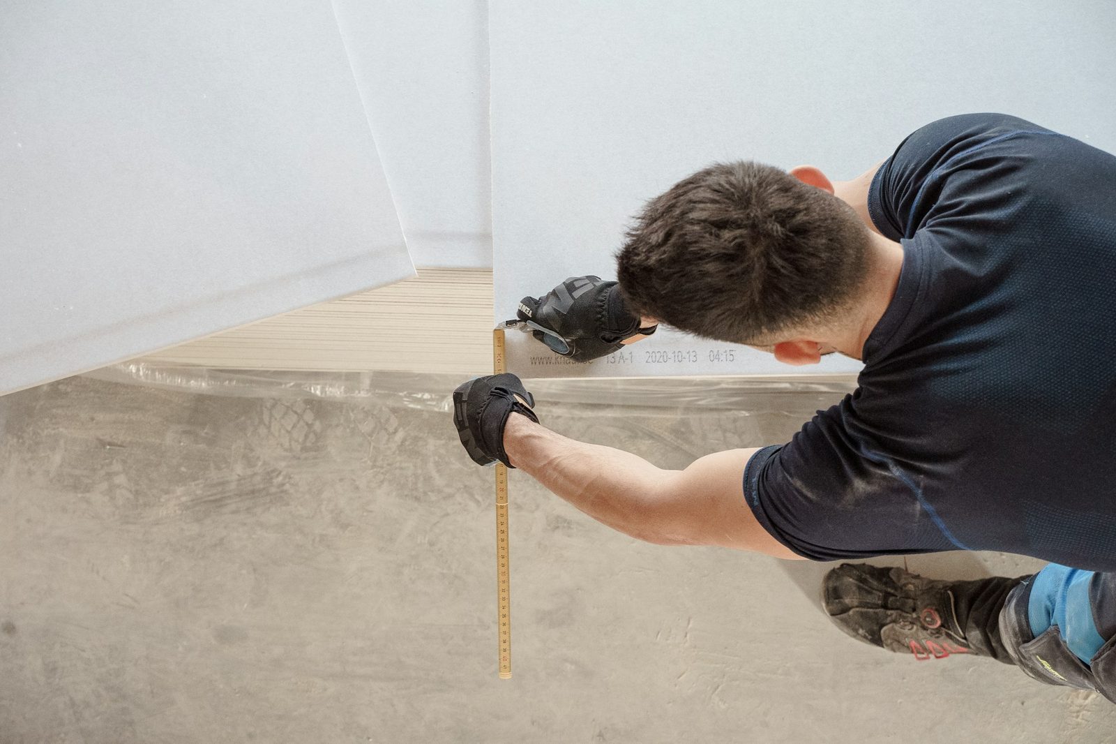 Carpenter measuring a floor during an on-site visit